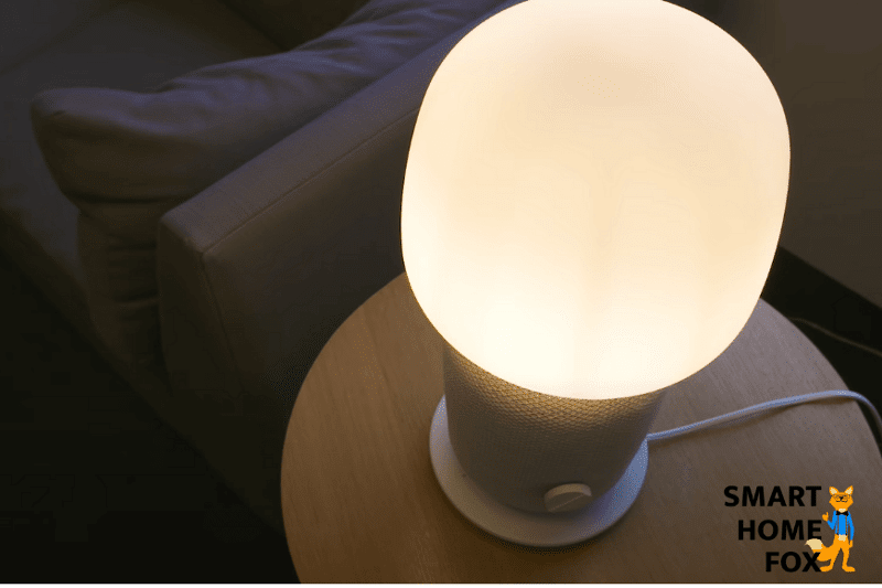 Man sieht die Symfonisk Tischleuchte auf einem Wohnzimmerschrank stehen.